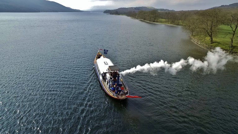 Drone shot from the air looking down at Steam Yacht Gondola sailing up Coniston